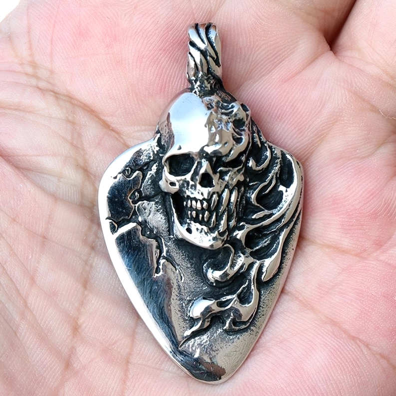 3D geschnitzter Totenkopf Gitarrenpick Anhänger in Hand gehalten von oben antike Silber Patina Finish Details sichtbar