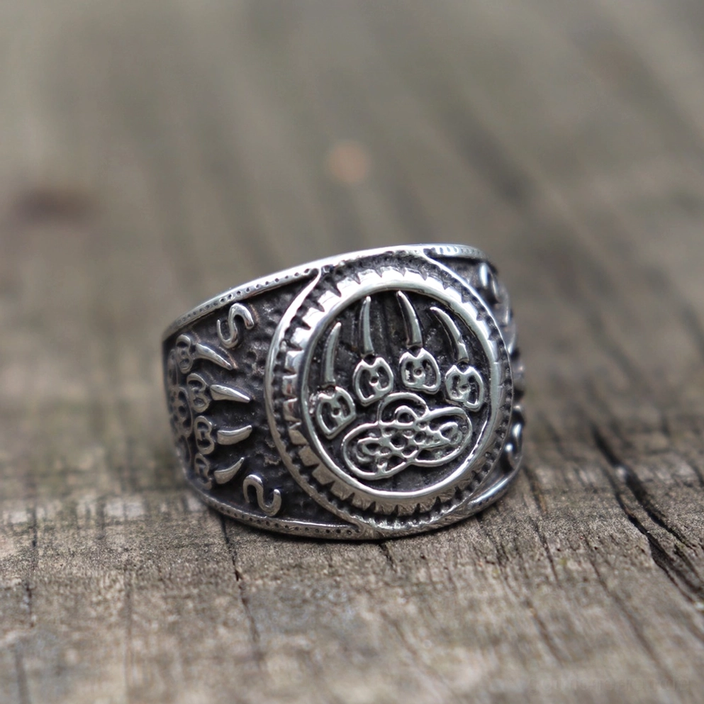 Bärenpfote Keltischer Knoten Gothic Amulett Ring – vordere Dreiviertelsicht auf dunklem Holzhintergrund zeigt kompletten Talisman-Ring mit gravierter Bärenpfote und vintage-Patina