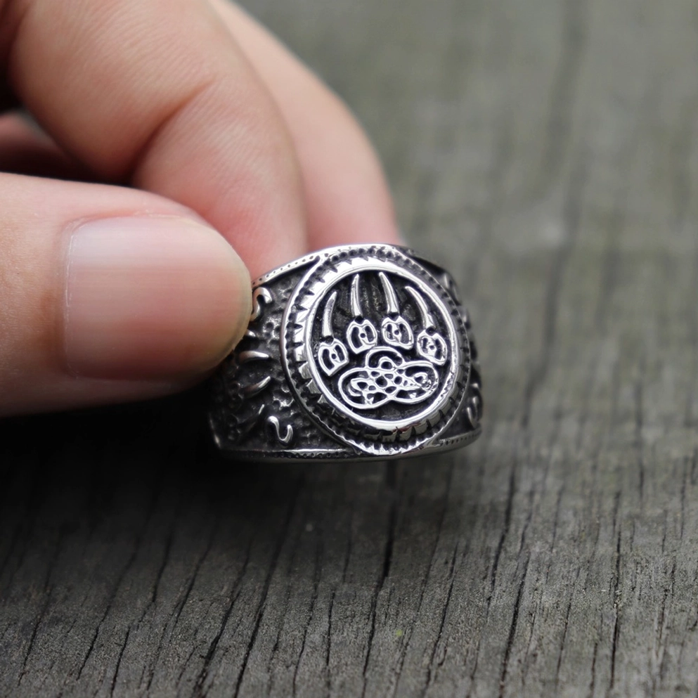 Bärenpfote Keltischer Knoten Gothic Amulett Ring – Vorder-Nahaufnahme in Fingern gehalten zeigt klare eingravierte Bärenpfote und vintage-silberner Edelstahl-Oberfläche