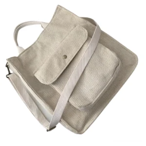 Beige Gothic Cord-Handtasche mit verstellbarem Schultergurt, 45-Grad Seitenansicht auf weißem Hintergrund, Detailaufnahme der gerippten Cord-Textur und Strukturmerkmale