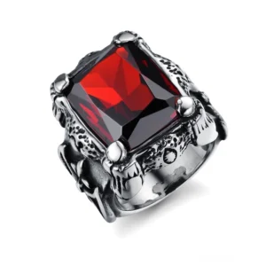 Blutroter quadratischer Zirkon Gothic Ring mit geschnitztem Edelstahl-Band und Vier-Krallen-Spannfassung in schrägem Oberblick, zeigt karminrot facettierten Edelstein und verzierte Edelstahl-Fassung mit gotischen Gravuren