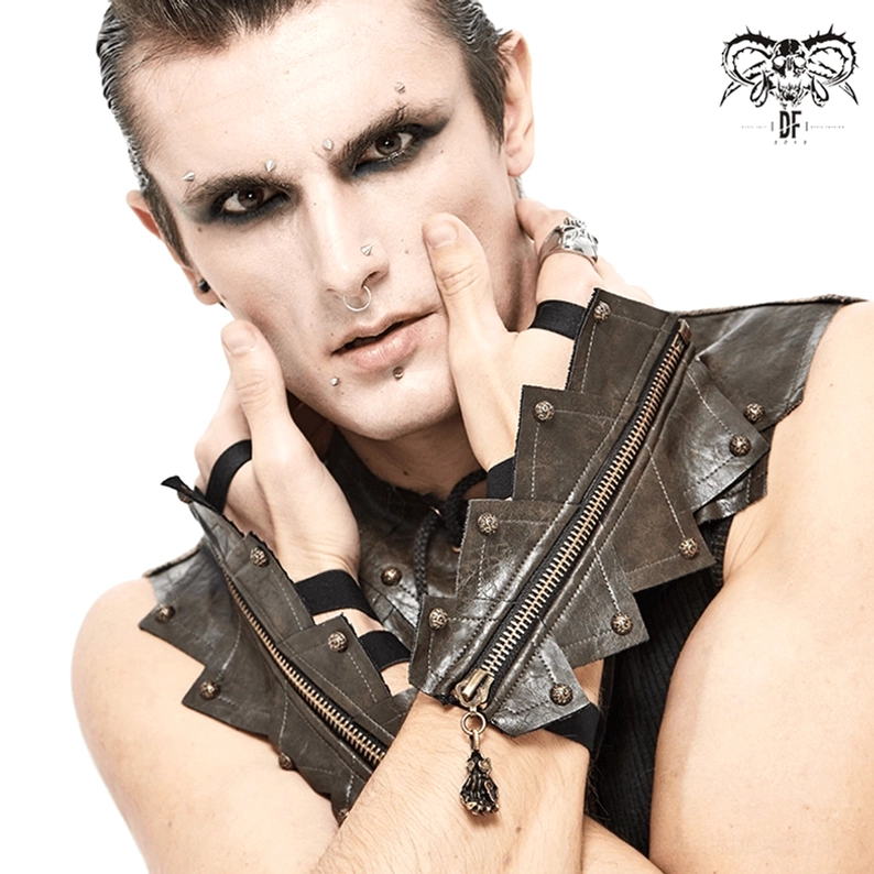 Männliches Modell mit Schulterpanzer trägt braune fingerlose Handschuhe mit Schädel-Reißverschluss, Gothic-Ästhetik mit mehrlagigen Handgelenksbändern