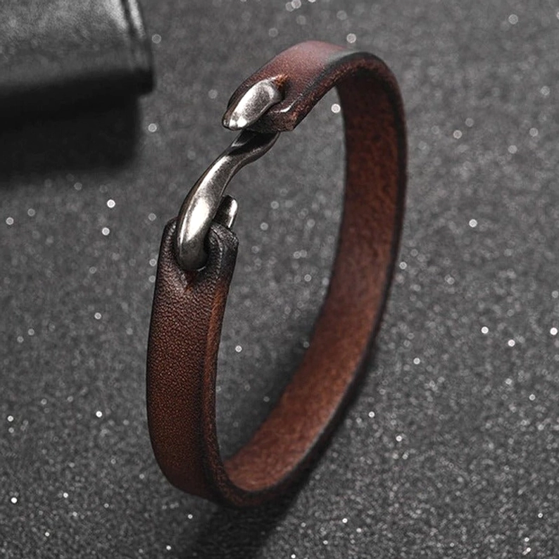 Detailaufnahme braunes Lederarmband, authentische Lederkörnung und Bootshaken-Verschlussmechanismus, gothic Handwerk