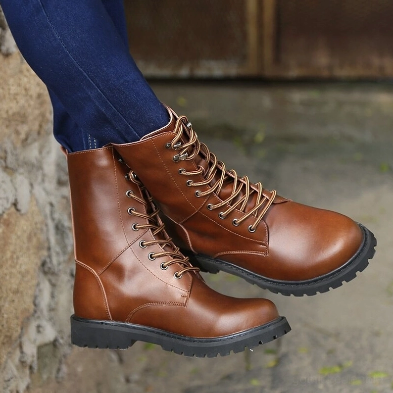 Braune hochschaftige Kombatstiefel mit dicker Gummisohle auf Außen-Natursteinoberfläche, sauberes Lederfinish und Haltbarkeitsmerkmale erkennbar