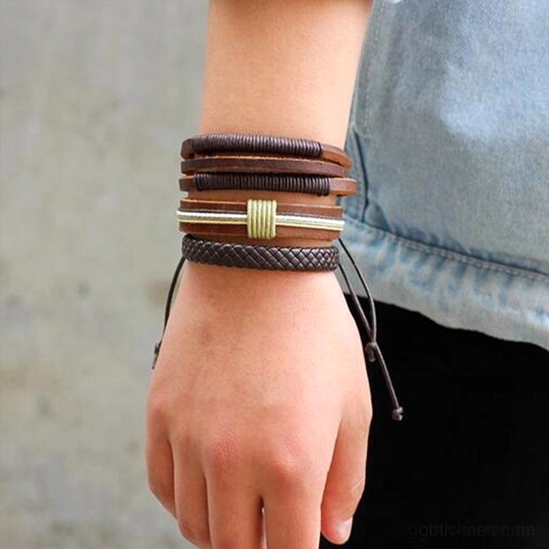 braunes leder gothic armband set getragen am handgelenk modell zeigt mehrere gestapelte armbander mit denim sleeve casual daily gothic look