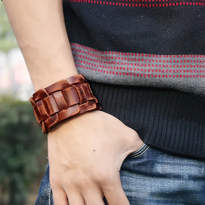 Braunes Leder Gothic Cuff Armband an der Hand getragen, Casual Outdoor Street Fashion Styling mit gestreiftem Pullover und Jeans, Darkwave Alternative Aesthetic Alltags-Look