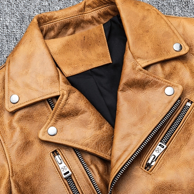 Detailaufnahme des Camel Leder Kragens mit silbernen Druckknöpfen und Reißverschlüssen auf der distressed Motorradjacke