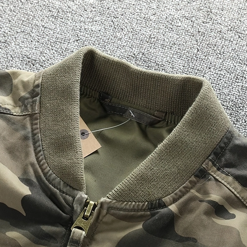 Nahaufnahme Metallreißverschluss-Zug und inneres Brand-Label auf Camouflage Denim Bomberjacke mit geripptem Kragen Detailfotografie