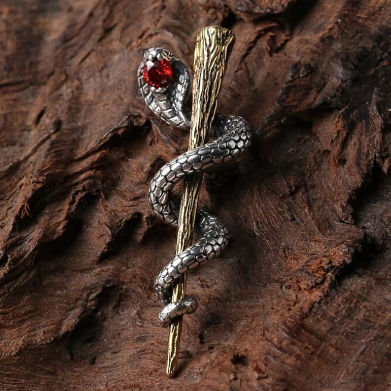 Seitenansicht des Sterlingsilber Cobra Anhängers mit roten Auge und strukturiertem Bronze Staff auf Holzhintergrund