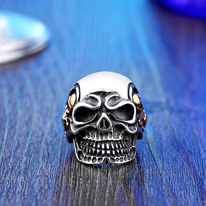 Chirurgischer Edelstahl-Dreifach-Totenkopf-Ring getragen, Nahaufnahme-Detailansicht mit Schädel-Finesse und Gothic-Schmuck-Authentizität