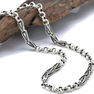 Vintage gedrehte sterling silber gliederkette halskette mit antiquierter patina und fischkaken verschluss auf holzoberfläche mit gotischem styling angezeigt