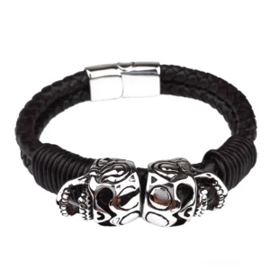 Doppelte Edelstahl-Totenkopf-Charms auf schwarzem geflochtenem Leder Armband mit Magnetverschluss, Studio-Produktfotografie Detail