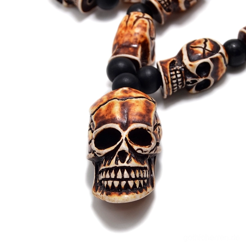 Nahaufnahme des gelbbraunen großen Totenkopf-Anhängers mit detailliert geschnitzten Gesichtszügen – gotischer Schmuck mit anatomischer Präzision