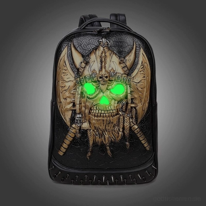 Goldener geprägter Totenkopf Gothic Rucksack mit grünem leuchtenden Augen-Effekt dunkelstudio-hintergrund