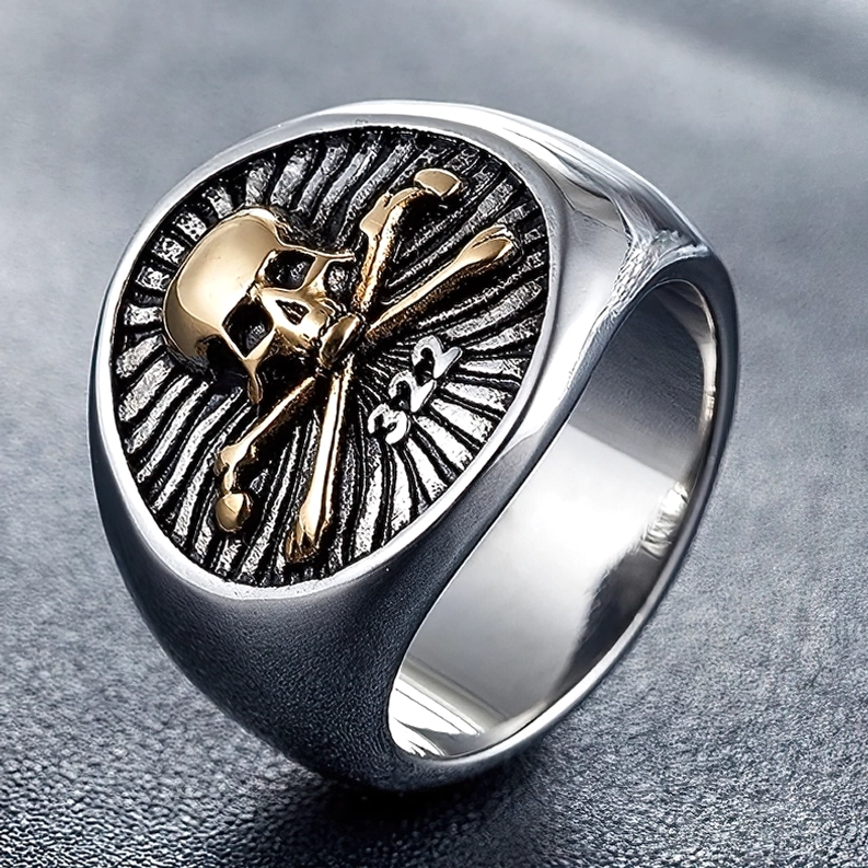 Goldener Totenkopf Sigelring mit radialer Oberflächenstruktur im gotischen Stil, Seitennahaufnahme auf dunklem Leder
