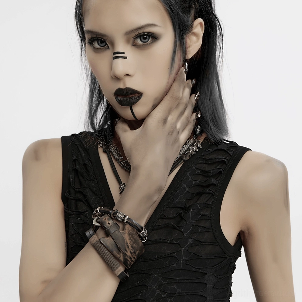 Seitenansicht gestresstes Leder und Metall gothic Armbänder auf weiblichem Handgelenk, zwei ergänzende Armband Stile, Alternative Fashion Accessoire Nahaufnahme, Vintage Punk Aesthetic