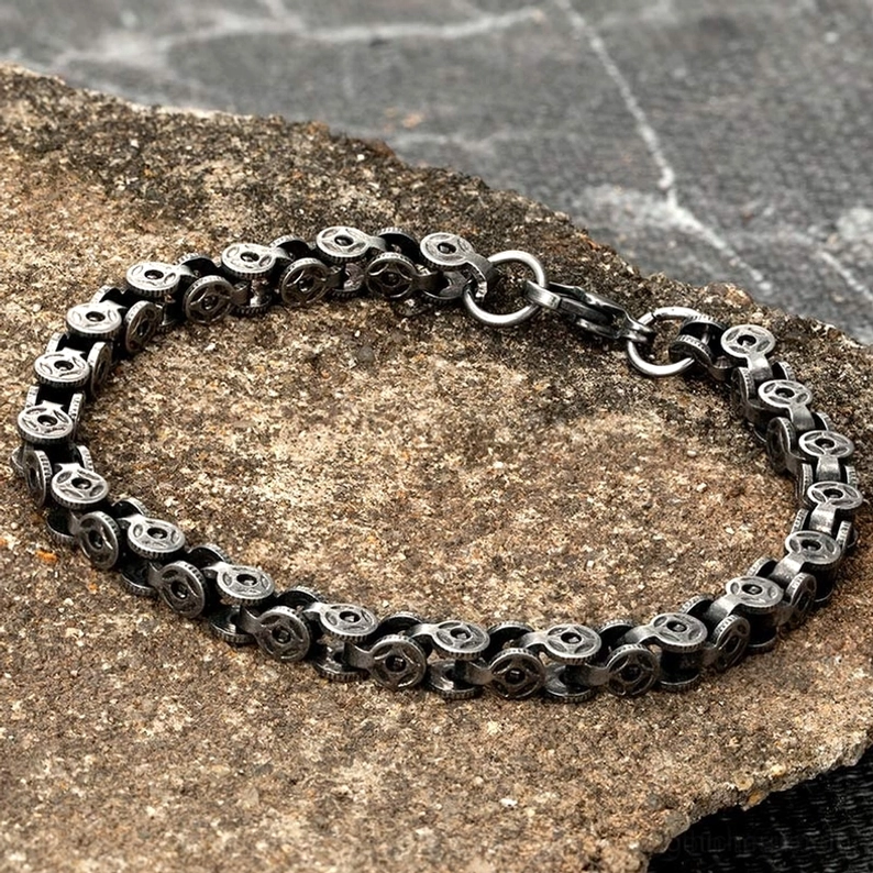 Dunkles Silber Gothic Kettenarmband für Herren auf rustikalem Steinuntergrund – Industrial Textur Vintage Patina Alternative Schmuck