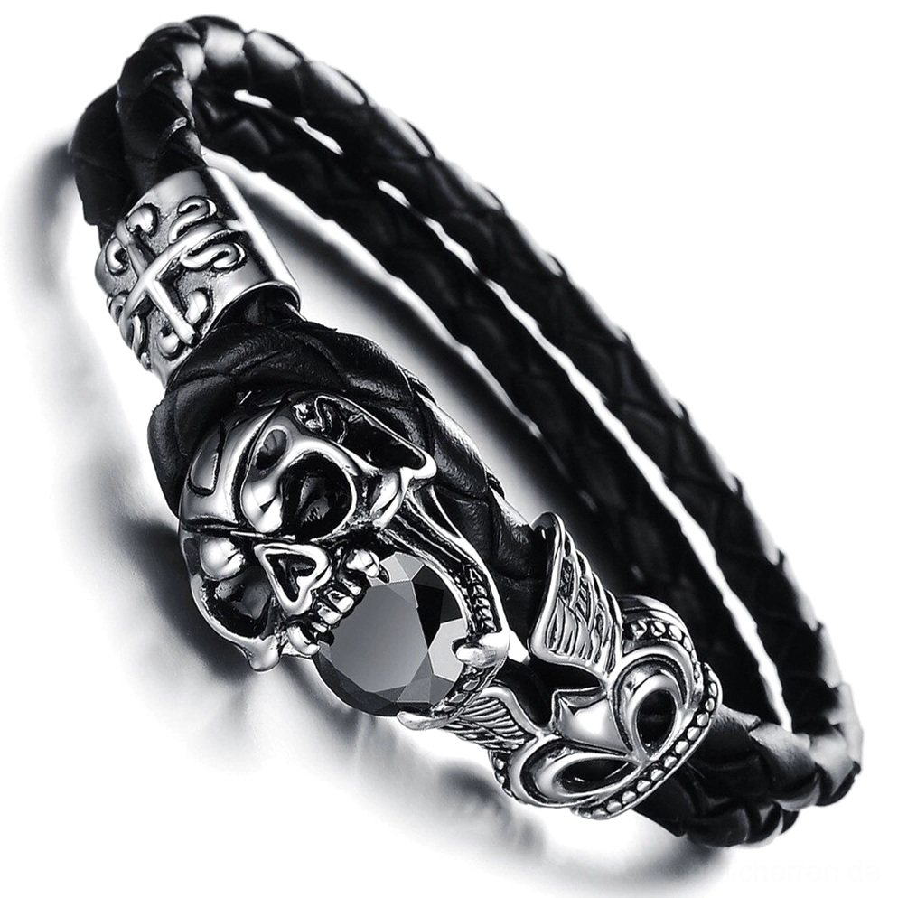 Detailnahe Seitenansicht des geflügelten Schädel-Charm Armbands mit verwinkeltem Edelstahl-Handwerk, sichtbarer geflochtener Leder-Konstruktion und schwarzem Zirkonia-Stein
