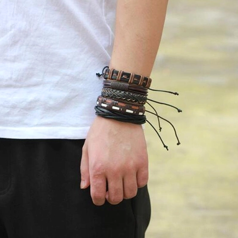 Mann trägt gestapelte Gothic Leder-Armbänder am Handgelenk - Verstellbare Zugschnur-Verschlüsse im Lifestyle-Außenbereich getragen