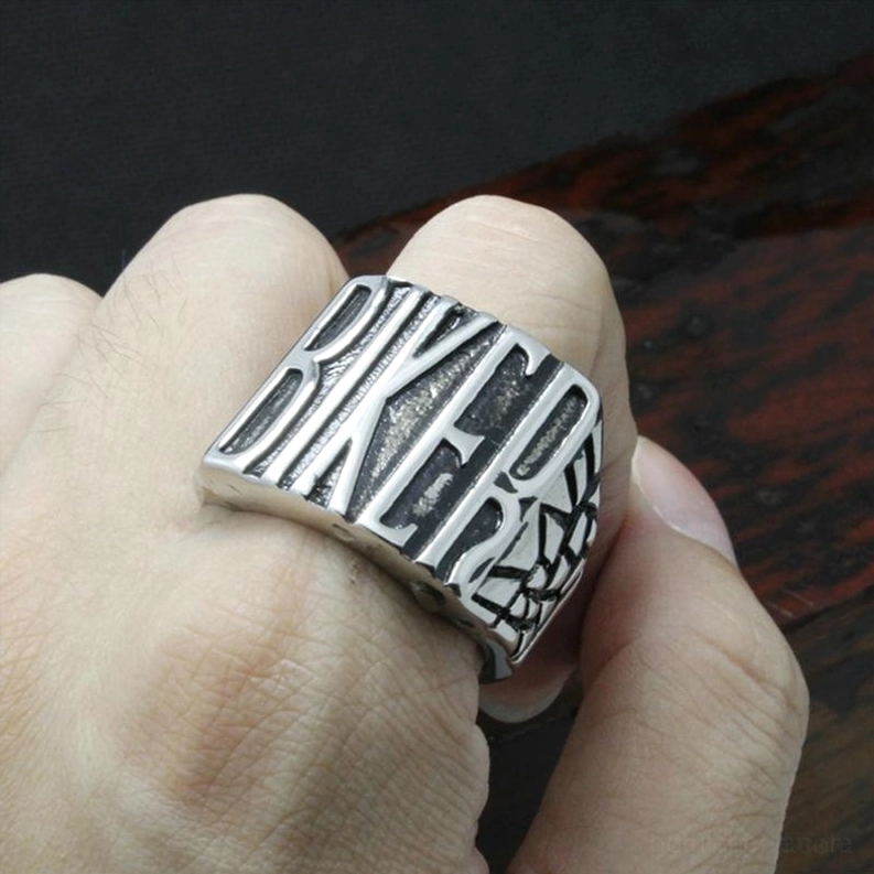 Gothic Biker Ring getragen an menschlichem Finger, seitliche Handansicht mit vintage Silberdesign auf dunklem Holzhintergrund, Größenreferenz Trageansicht