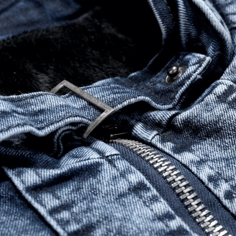 Metallischer Reißverschluss-Detail einer Gothic-Denim-Bikerjacke mit Premium-Hardware und sichtbarem luxuriösem flauschigem Plüsch-Innenfutter, distressed Denim-Textur, hochwertige Verarbeitung
