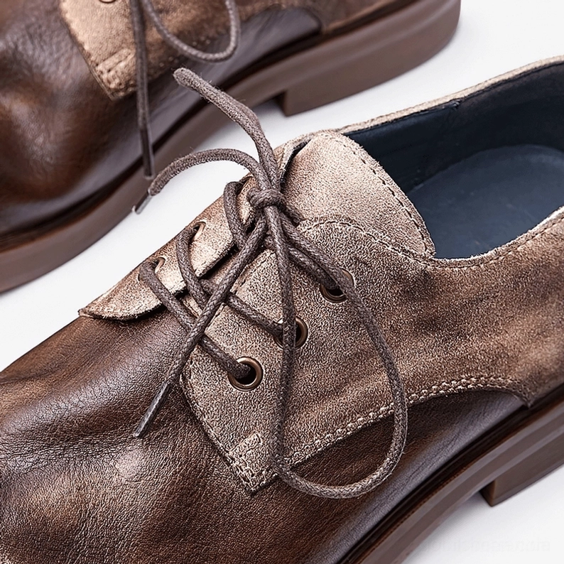 Close-up detail shot of men's distressed leather gothic boots showing two-tone finish variation, lace-up closure system, contrast stitching and authentic aged leather texture craftsmanship