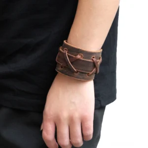 Gothic Vintage Braun Lederarmband Cross-Lace an männlichem Arm getragen, Seitenansicht mit charakteristischer Distressed-Textur und verstellbarem Metallschloss, echtes Handwerk sichtbar