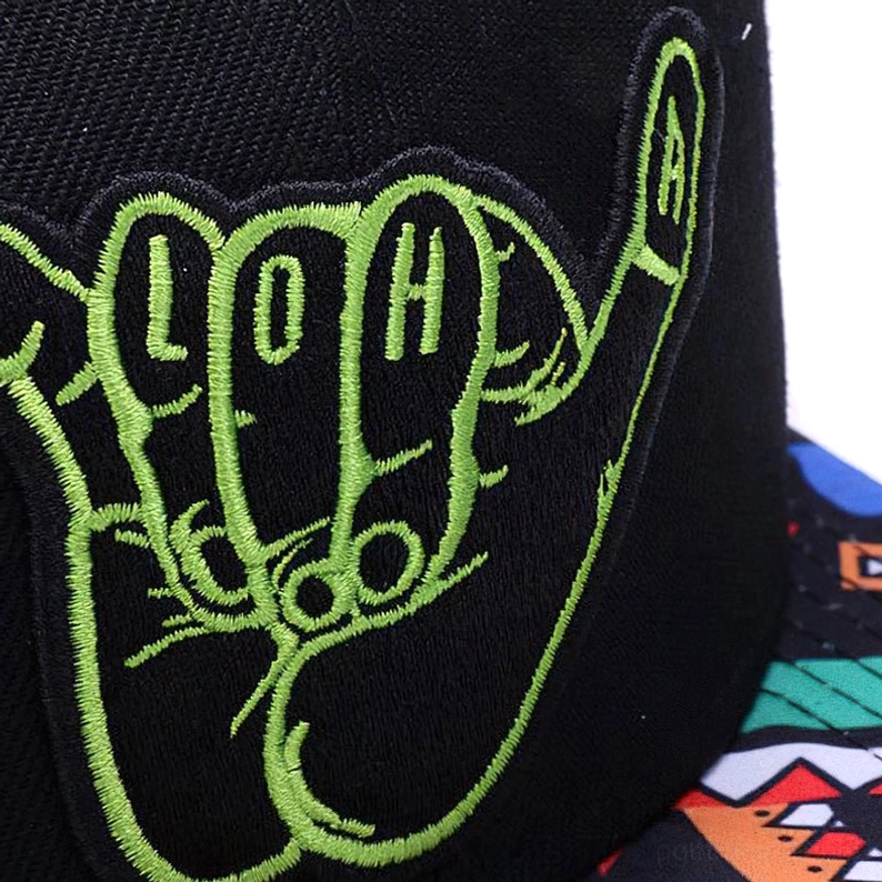 Nahaufnahme-Detail der neongrünen hand-gestickten Shaka-Hand mit LOH-Buchstaben auf schwarzem Baumwoll-Twill-Stoff der Gothic Cap