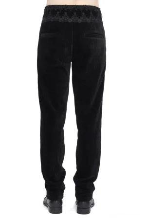 Gotische schwarze Corduroyhose von hinten, zeigt detailliert die Spitzentaille, Leistentasche und strukturelle Verarbeitung der Rückseite
