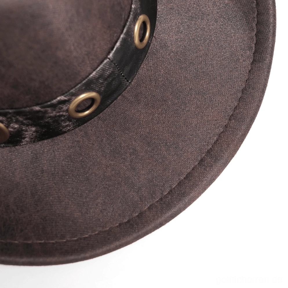 Brauner Gothic Cowboyhut Frontalansicht auf Schaufenster-Display, Betonung der Metallkugel- und Spike-Trim-Details, strukturiertes Kunstleder und industrielle Designelemente des Hutbandes