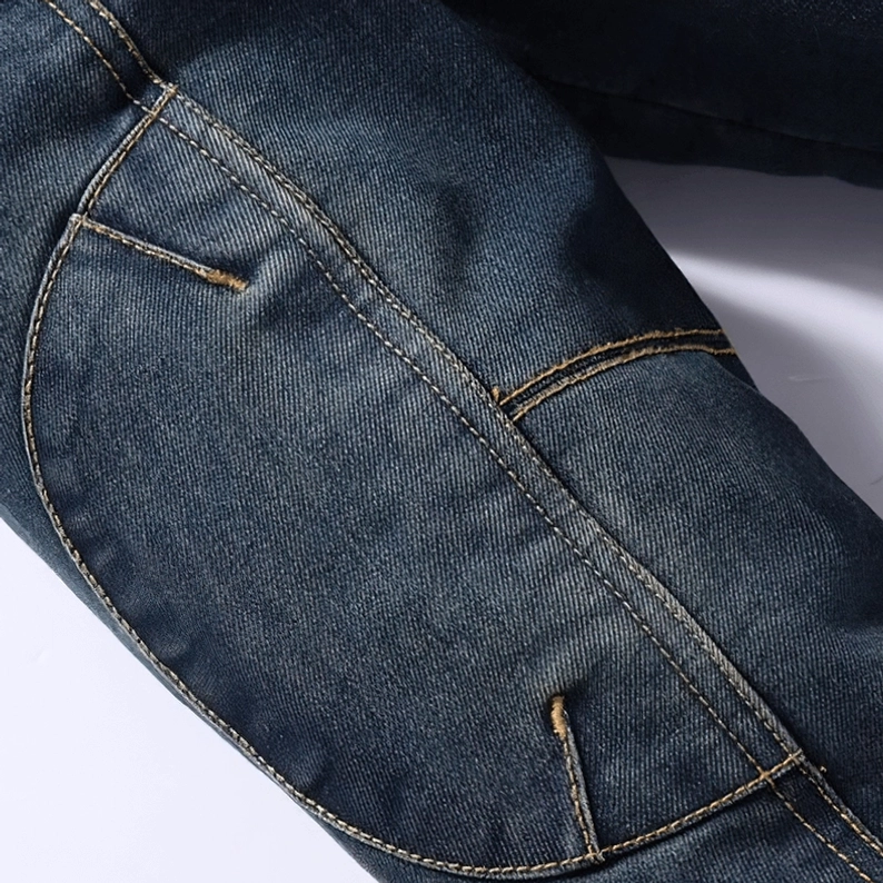 Nahaufnahme Herren Gothic Denim Jacke Seitentasche, dunkle Waschung Denim Stoff, kontrastgelbe Stickereia, verstärkte Metallnieten, schräggestellte Tascheneröffnung
