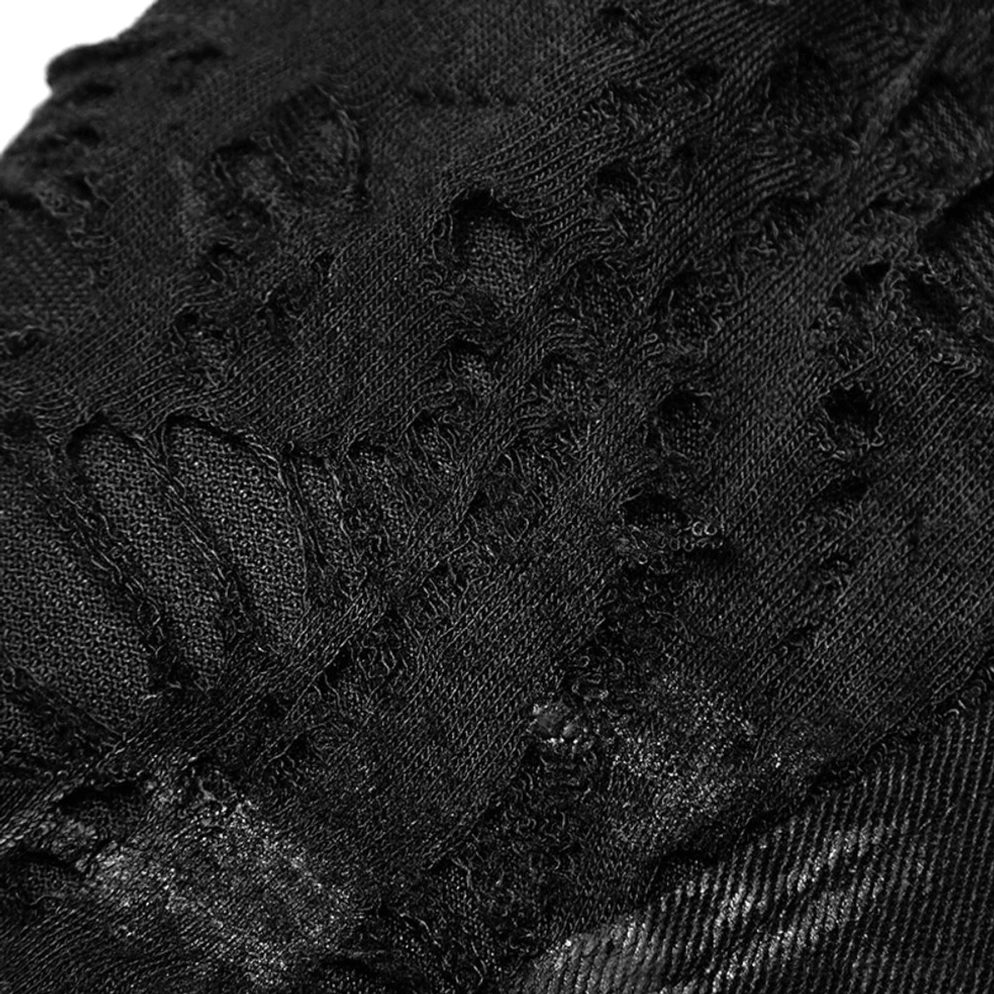 Makro-Nahaufnahme zerrissene und beschädigte schwarze Denim-Fabrik-Textur mit absichtlichen Verschleißmustern