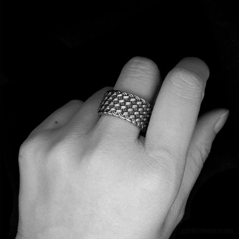 Schwarz-Weiß künstlerische Aufnahme des geflochtenen Gothic Edelstahl Rings an Herrenhand