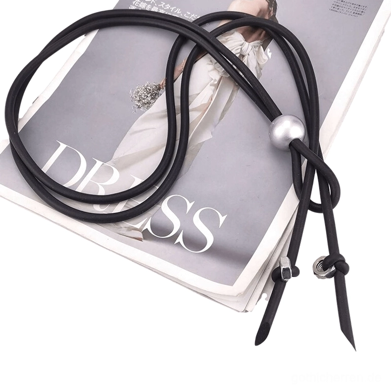 Aufgerollte schwarze Gummi-Lariat-Halskette mit silberner Sphäre und geknoteten End-Befestigern, auf Fashion-Magazine-Hintergrund – Gothic-Schmuck Lifestyle-Fotografie
