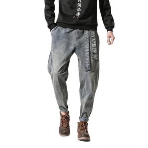 Herrenharem-Jeans in melancholischem Grau mit Kordelzug-Verschluss, komplette Ganzkörper-Modellansicht mit braunen Arbeitsboots