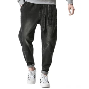 Herrenharem-Jeans im Gothic-Stil mit verwaschener schwarzer Waschung und Kordelzug, Vorderansicht der unteren Körperhälfte mit hochgerollten Säumen