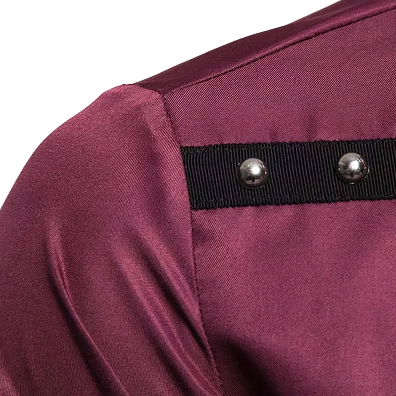 Nahaufnahme Makro-Detail des Burgund-Gothic-Hemdes mit schwarzem Webgurt und zwei runden Metallnieten