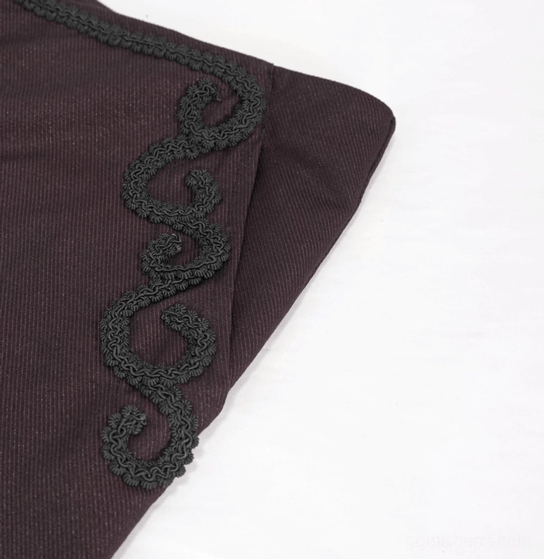 Makro-Aufnahme der eleganten schwarzen Rankenwerk-Spitzenverzierung an der Seitentasche der weinroten Gothic Röhrenhose
