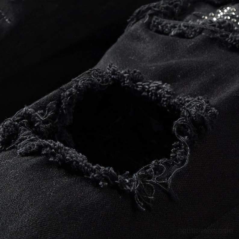 Ausgefranste zerrissene Denimöffnung Zerstörungsdetail schwarze Gothic Stil Jeans Nahaufnahme