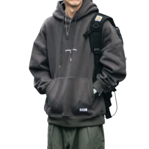Herren-Kapuzenpullover in dunklem Grau mit gothic Oversized-Schnitt, Zugkordel-Kapuze und Känguru-Vordertasche, Vorderansicht auf weißem Hintergrund