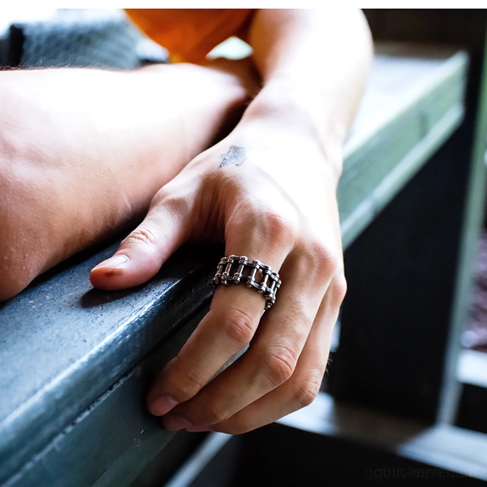Mann trägt Gothic Kettenring am Zeigefinger im Freien, zeigt Passform und Punk-Rock-Style Statement-Schmuck mit dunkler Ästhetik