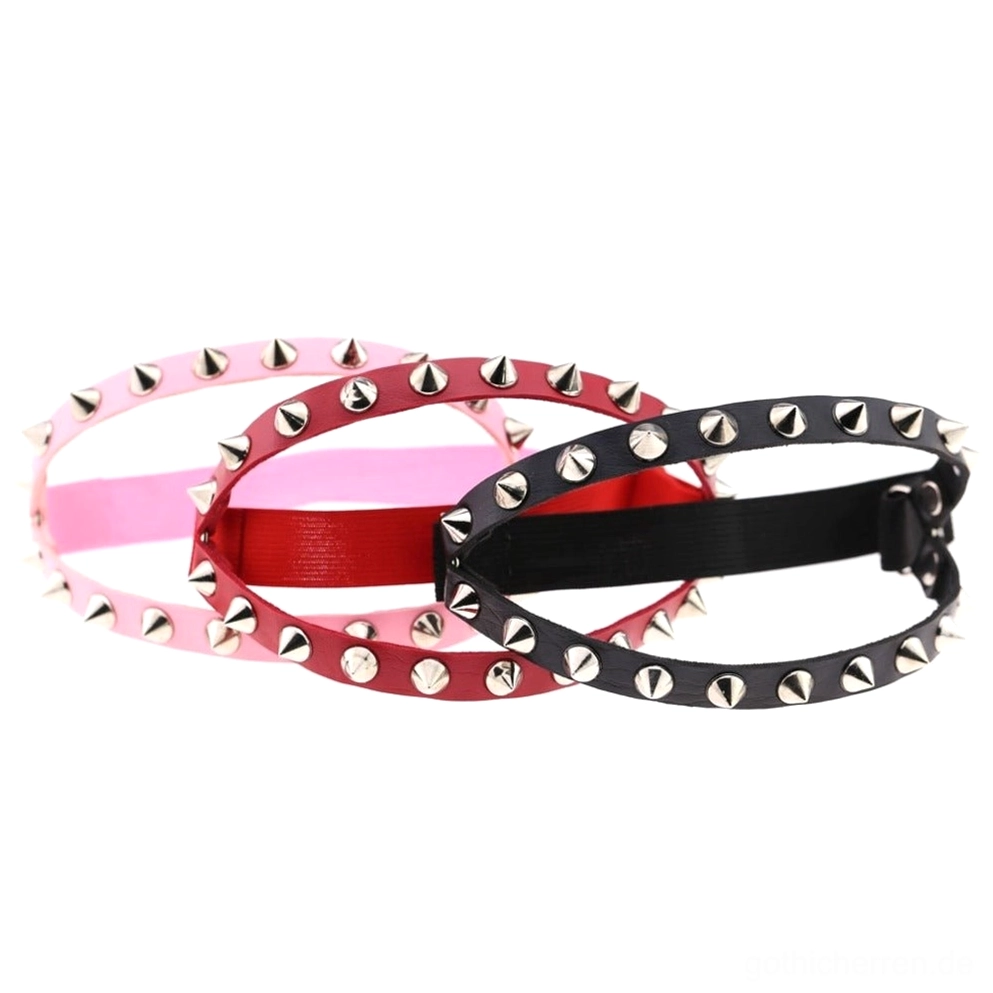Drei Gothic Spiked Knee Garter Belts Paar nebeneinander in Seitenansicht-Flatlay, Kegelnieten und verstellbare Schnallen in verschiedenen Farben, industrielles Leder-Harness-Design