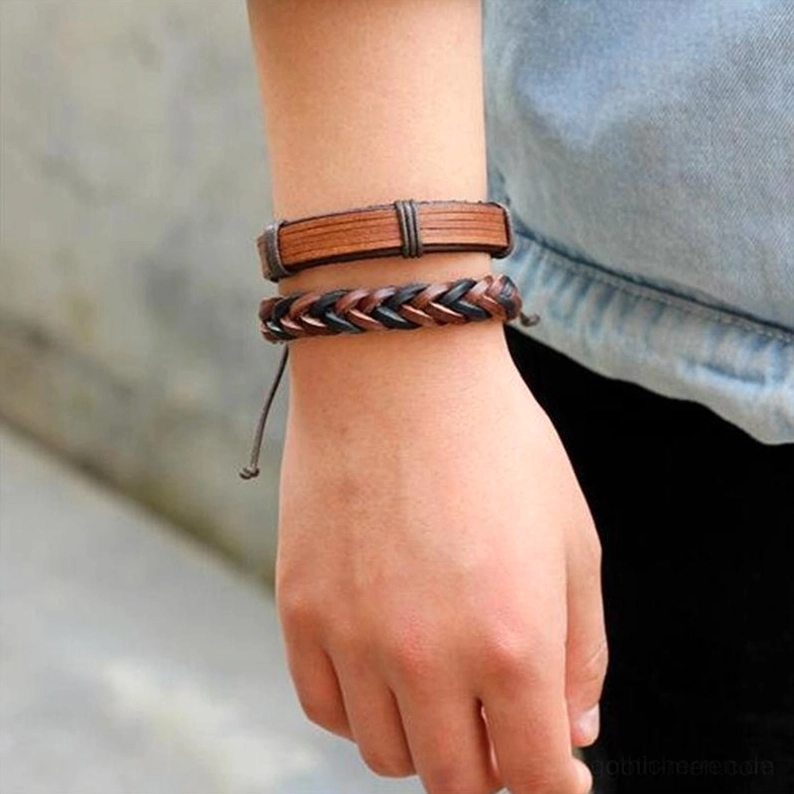 einzelne gothic leder armbander auf hand zeigt flaches band geflochtenes seil designs verstellbare zugverschlusse alternative asthetik braun