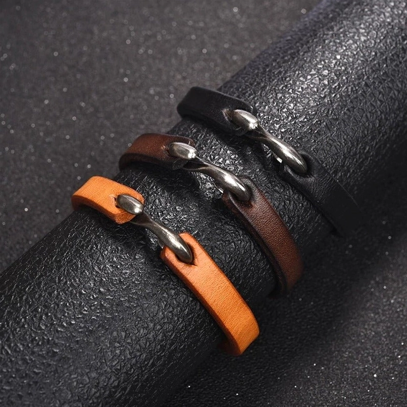 Mehrere Lederarmbänder gestapelt, schwarze und braune Farben, Styling-Inspiration für geschichtete neo-gothic Ästhetik