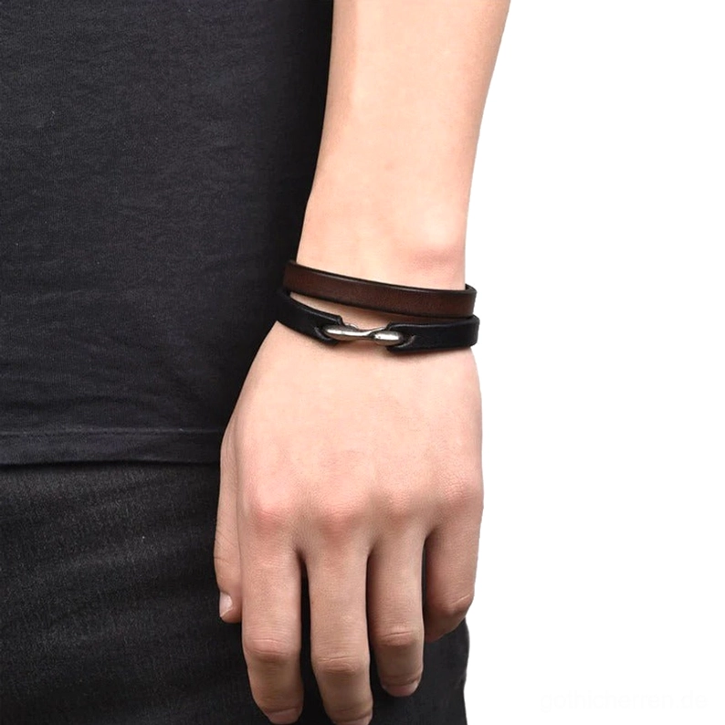 Styling-Ansicht: Mann mit zwei geschichteten Lederarmbändern, schwarz und braun, Bootshaken-Verschlüsse, tägliches Tragen neo-gothic