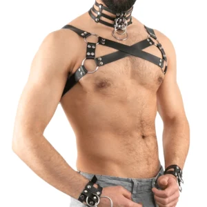 Schwarzes Gothic Ledergeschirr für Herren mit gekreuzten Schultergurten und Metall-D-Ringen, linke Vorderansicht auf männlichem Modell, PU-Kunstleder-Brustharness