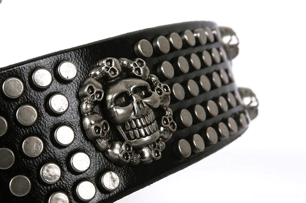 Makro-Nahaufnahme des gotischen Ledergürtels mit großem zentralem Totenkopf-Metallornamet und dicht besetzten runden Nieten