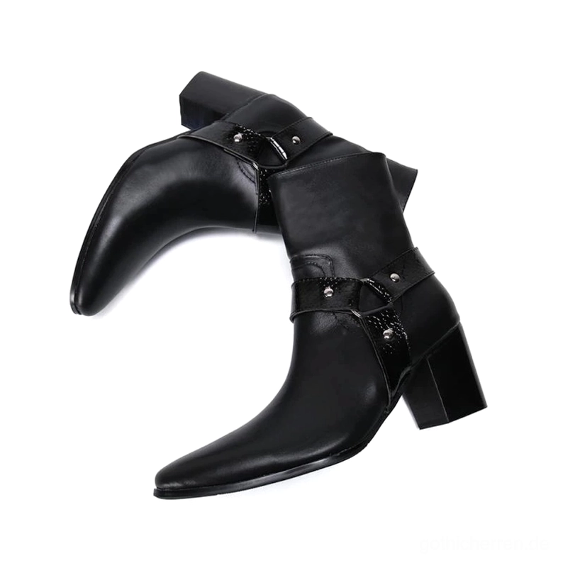 Paar schwarzer Leder-Gothic-Stiefel gekreuzt zur Schau gestellt, zeigt Metallriemen-Schnalle und Spitzform Detail