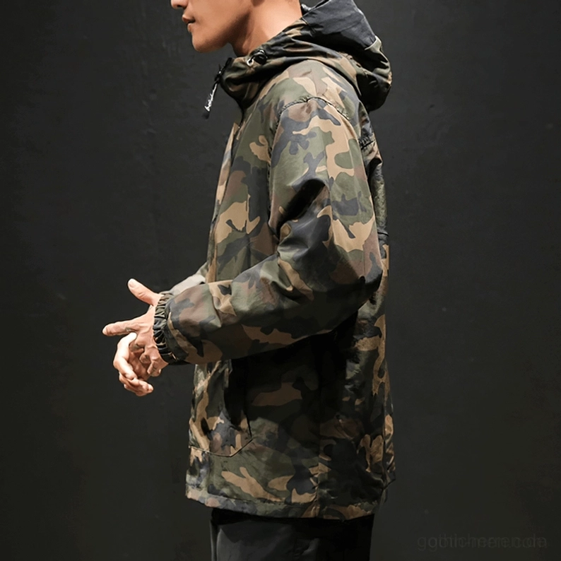 Vorderansicht männliches Modell in Gothic-Military-Camouflage-und-Schwarz-Half-Zip-Kapuzenpullover, verstellbare Kordel am Saum, Oversized-Passform, Übergangsmode, dunkler Hintergrund