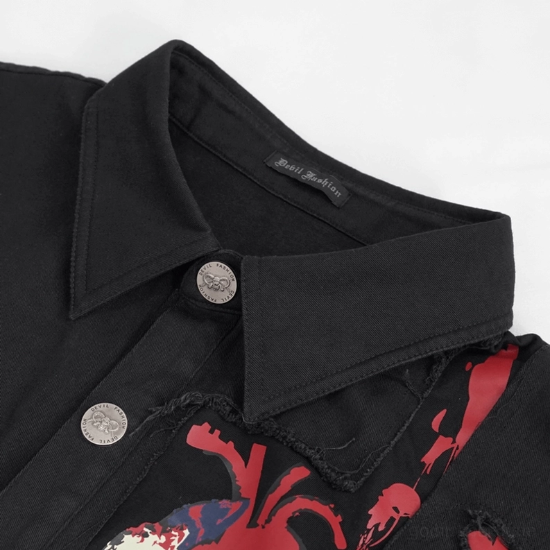 Nahaufnahme spitzer Hemdkragen, silberne Metallknöpfe und Marken-Stoff-Etikett auf schwarzem gotischem Muskelshirt zeigen hochwertige Hardware-Details